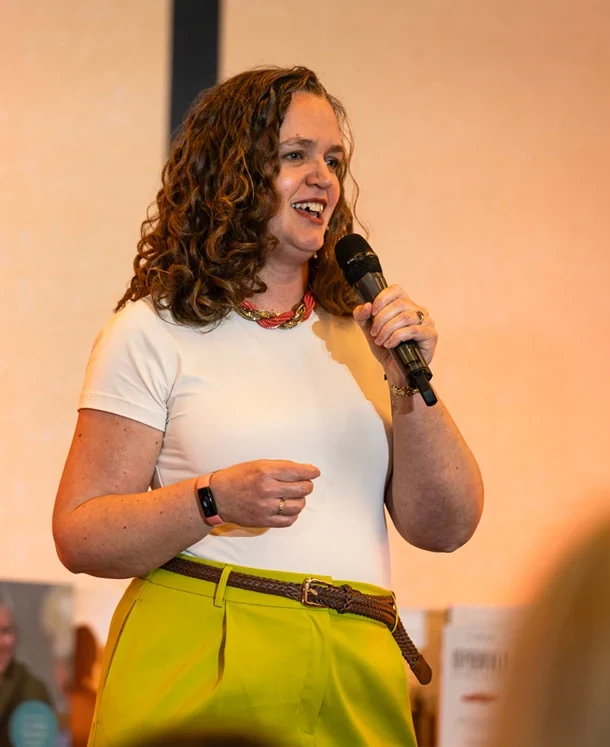 Jen Goddard speaking and smiling at a live event